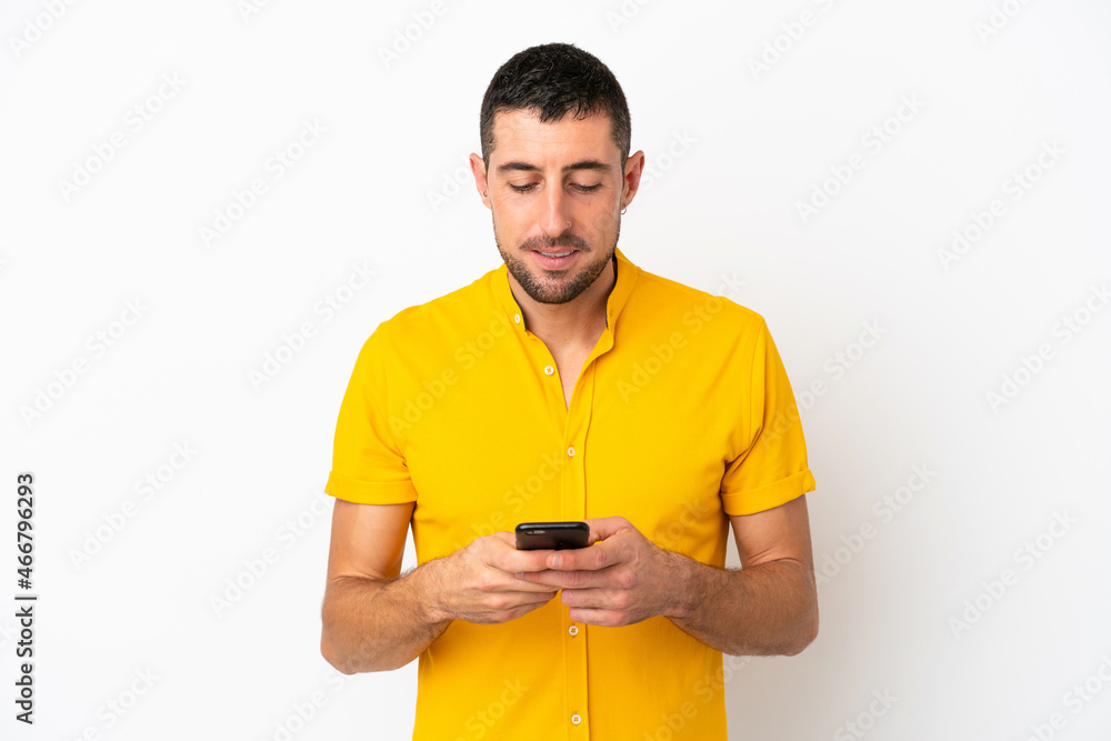 Young handsome caucasian man isolated on white background sending a message with the mobile
