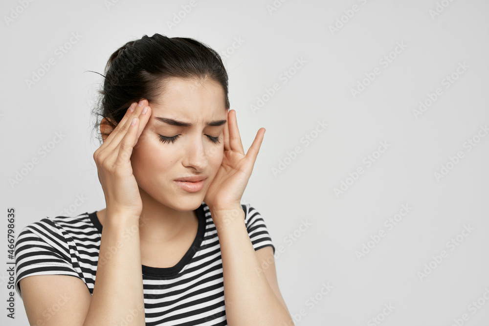 brunette in a striped t-shirt pain in the neck light background brunette in a striped t-shirt pain in the neck light background