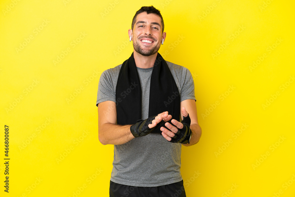 Young sport caucasian man isolated on yellow background applauding after presentation in a conference Young sport caucasian man isolated on yellow background applauding after presentation in a conference