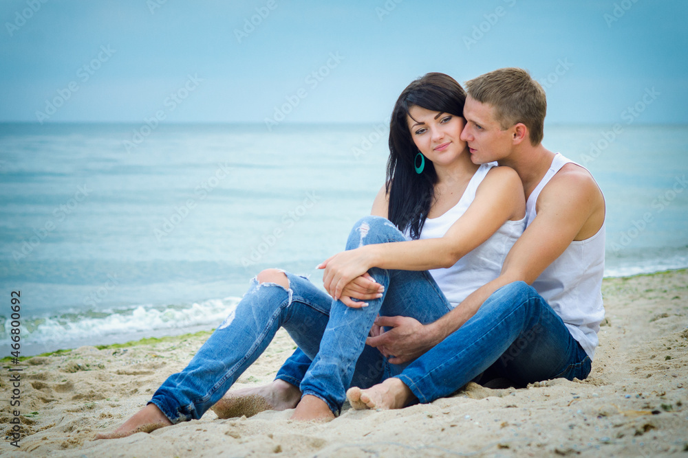 guy and a girl in jeans and white t-shirts on the beach guy and a girl in jeans and white t-shirts on the beach