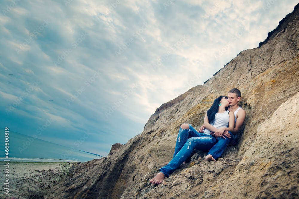 guy and a girl in jeans and white t-shirts on the beach