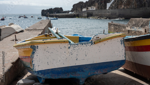 Old, colorful fishing boats on the shore of Atlantic Ocean. Camara de Lobos village, Funchal, Madeira Island. Selective focus. 