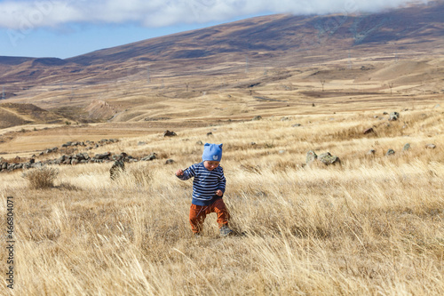 One year old boy walks on a mountain plateau