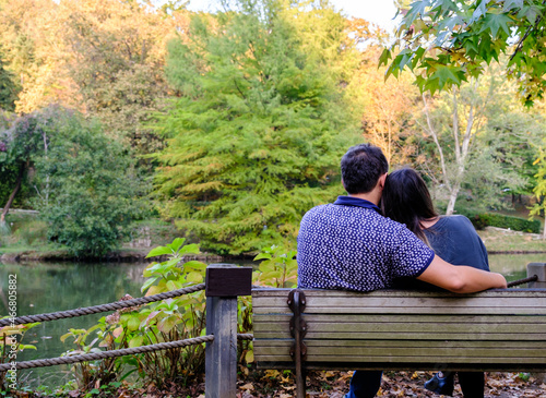 Couple sitting on bench and hugging each other in the forest, retirement concept idea with copy space