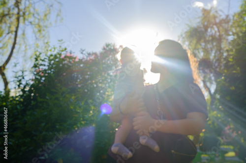 Mother and daughter are hugging, sun flare effect, happy mothers day concept idea,blur photo