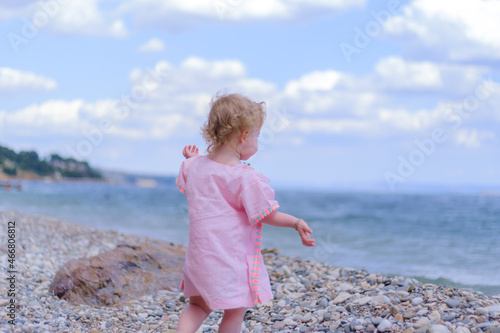 Close up of blonde little girl looking sea or ocean at the beach, holiday concept idea