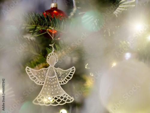 White lacy angel ornament. Christmas card. Bokeh, blured