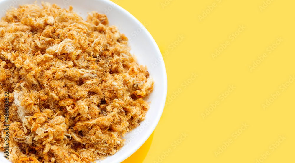 Dried shredded pork in white plate on yellow background. Dried shredded pork in white plate on yellow background.