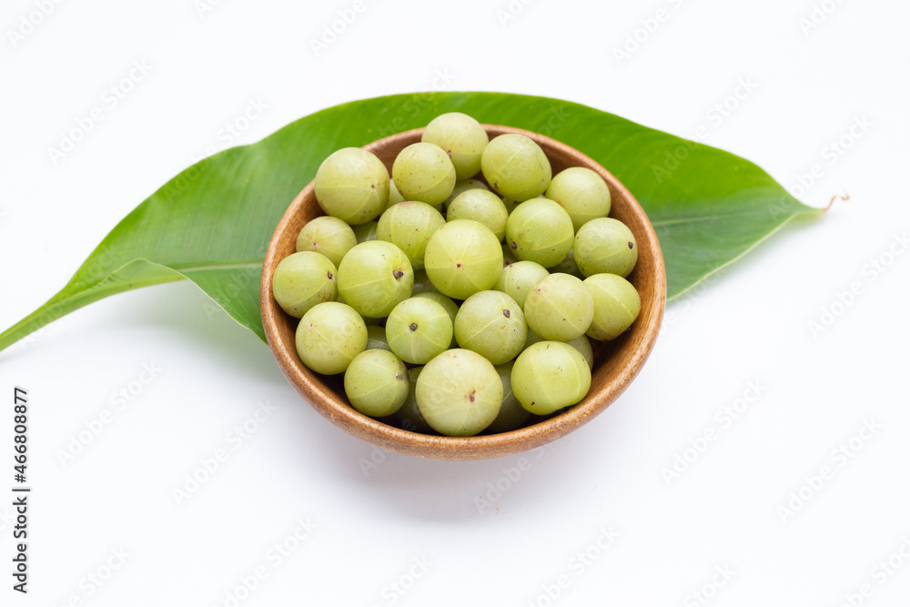 Fresh emblica in wooden bowl on white background. Fresh emblica in wooden bowl on white background.