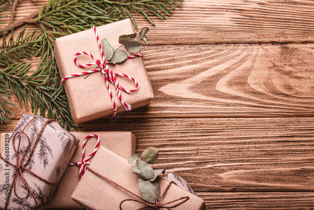 Wrapped Christmas presents flat lay composition with fir tree branch on wooden background. Christmas and New Year gift boxes top view with free space for text template Wrapped Christmas presents flat lay composition with fir tree branch on wooden background. Christmas and New Year gift boxes top view with free space for text template