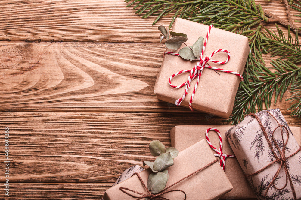Wrapped Christmas presents flat lay composition with fir tree branch on wooden background. Christmas and New Year gift boxes top view with free space for text template Wrapped Christmas presents flat lay composition with fir tree branch on wooden background. Christmas and New Year gift boxes top view with free space for text template