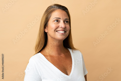 Middle age brazilian woman isolated on beige background . Portrait