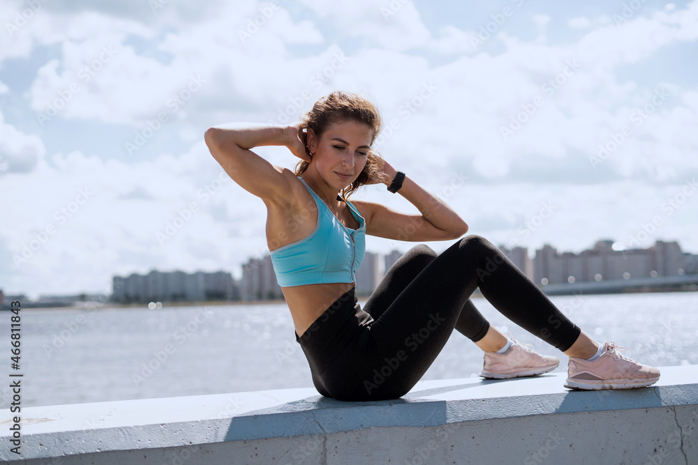 Coach exercises on the street. Healthy lifestyle. A woman does a stretching workout. An athlete in sportswear. Outdoor fitness in the city. Coach exercises on the street. Healthy lifestyle. A woman does a stretching workout. An athlete in sportswear. Outdoor fitness in the city.