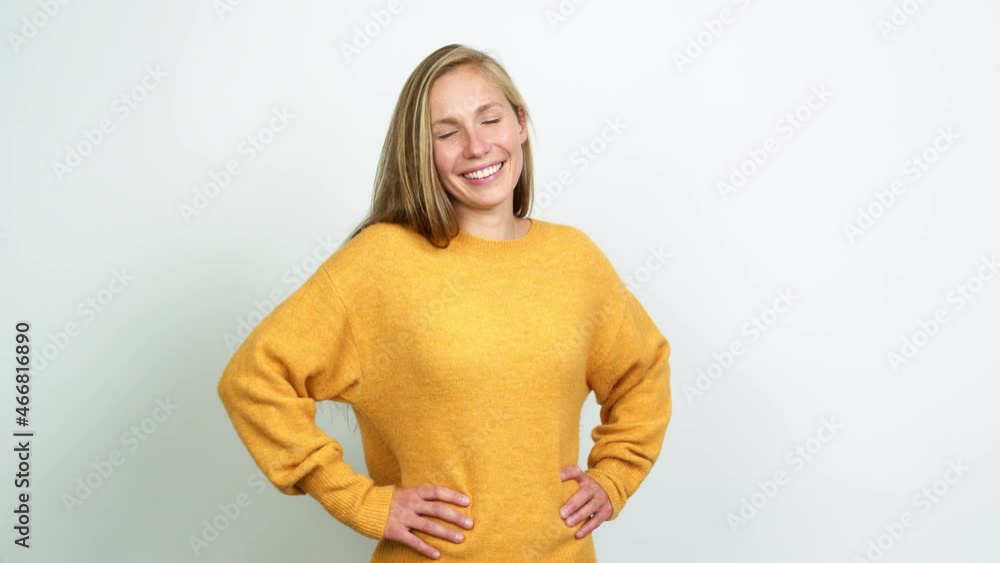 Young blonde girl posing with arms at hip and laughing over isolated background Young blonde girl posing with arms at hip and laughing over isolated background
