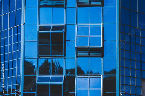facade of a modern house, blue glass wall of a high-rise building, windows of a multi-storey building