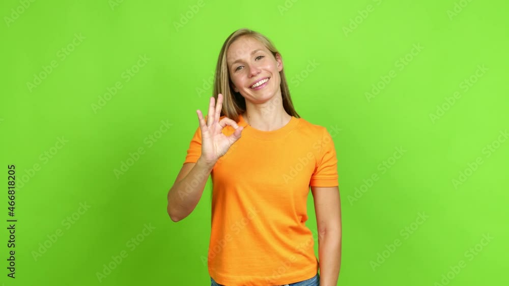Young blonde girl showing ok sign with fingers over isolated background. Green screen chroma key Young blonde girl showing ok sign with fingers over isolated background. Green screen chroma key