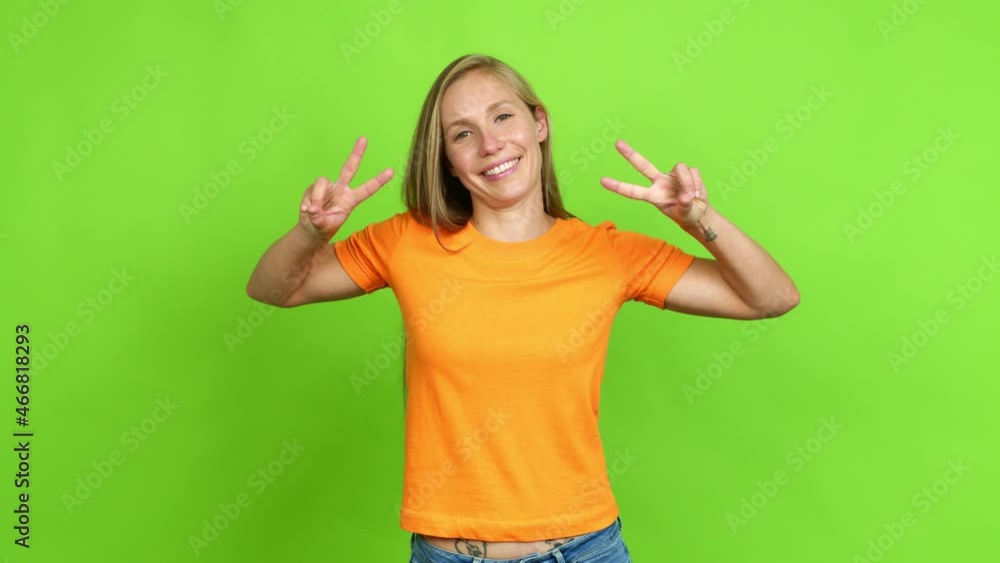 Young blonde girl smiling and showing victory sign with a cheerful face over isolated background. Green screen chroma key Young blonde girl smiling and showing victory sign with a cheerful face over isolated background. Green screen chroma key