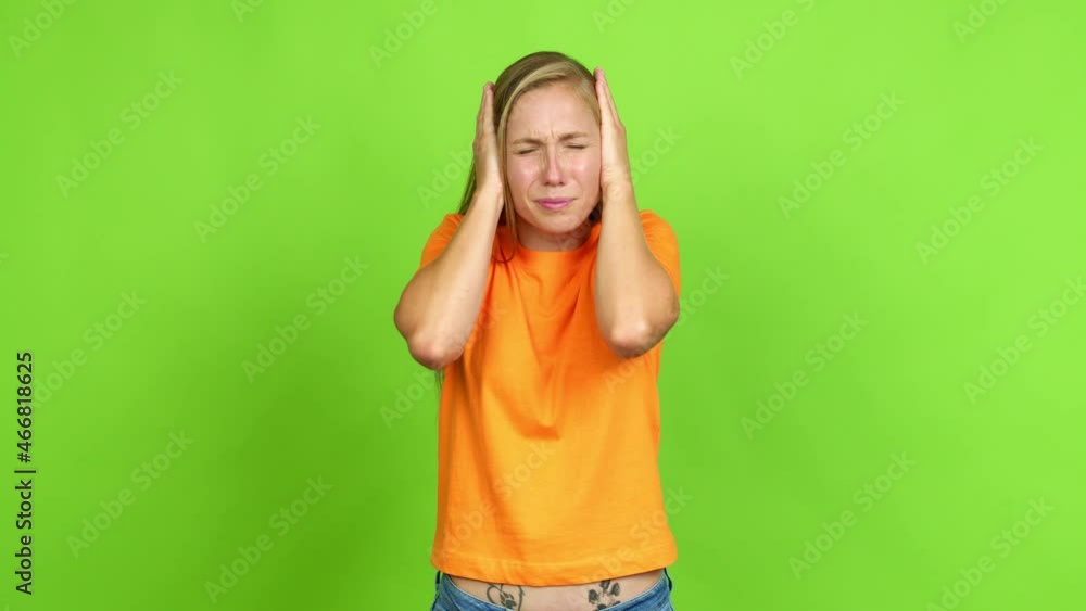 Young blonde girl covering both ears with hands. Frustrated expression over isolated background. Green screen chroma key Young blonde girl covering both ears with hands. Frustrated expression over isolated background. Green screen chroma key
