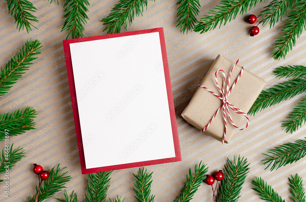 Fototapeta premium Christmas or New Year greeting card mockup with gift box and fir tree branches
