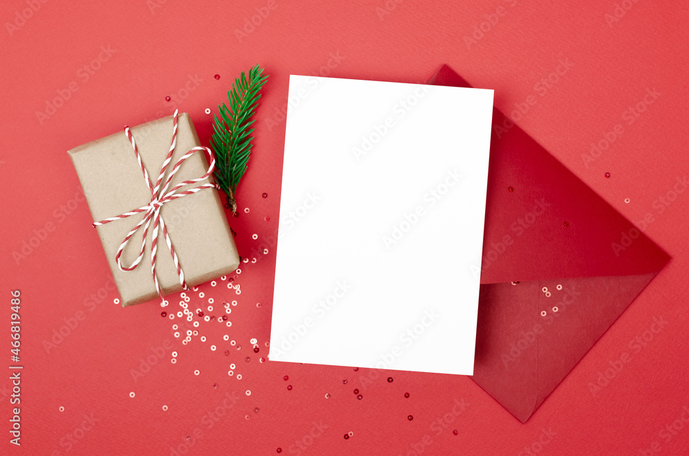Christmas greeting or invitation card mockup with envelope, gift box and festive confetti decorations on red Christmas greeting or invitation card mockup with envelope, gift box and festive confetti decorations on red