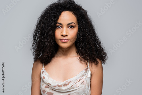 Pretty young african american woman looking at camera isolated on grey