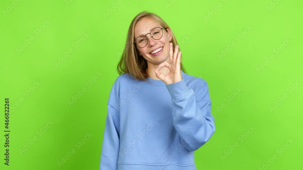 Young blonde girl with glasses and doing ok sign. Green screen chroma key Young blonde girl with glasses and doing ok sign. Green screen chroma key