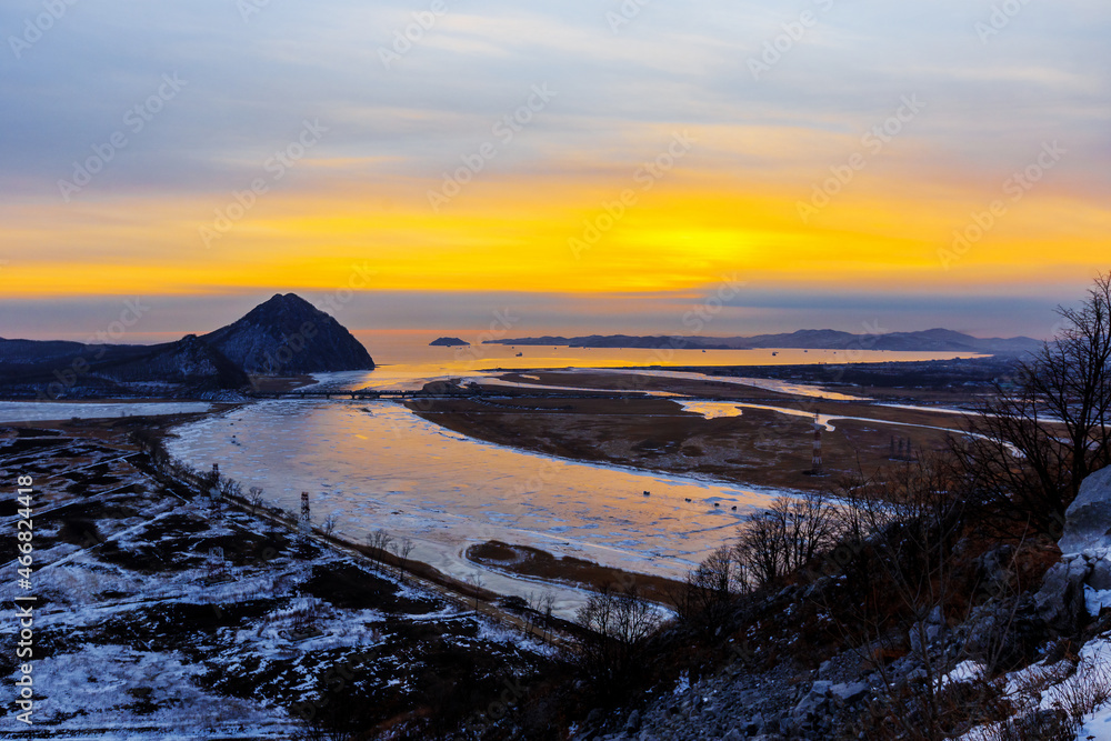Obraz premium Mount Sister in the city of Nakhodka during a bright dawn. Beautiful mountain against the background of the winter sea.