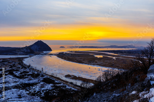 Mount Sister in the city of Nakhodka during a bright dawn. Beautiful mountain against the background of the winter sea.