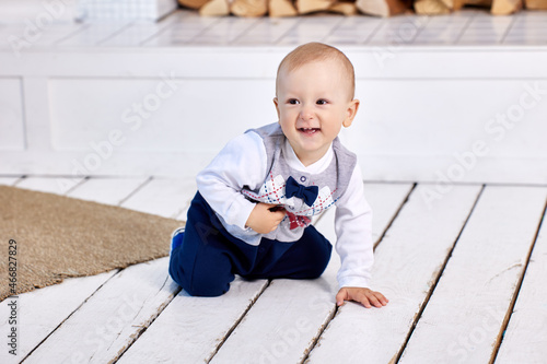 White cheerful toddler crawls on floor in living room.