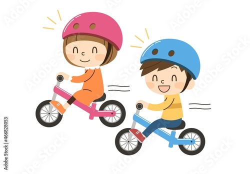 笑顔でキックバイクに乗る2人の子供