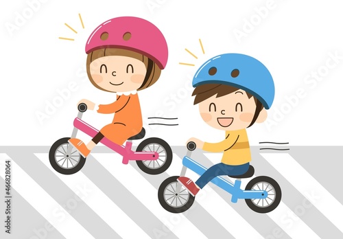 横断歩道でキックバイクに乗る2人の子供