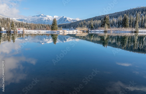 Pedestrian bridge and reflections in Cascade Pond in Banff National Park, Canada
