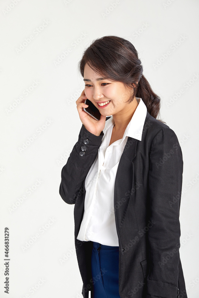 A business woman in her 30s who works on the phone on the move. A business woman in her 30s who works on the phone on the move.