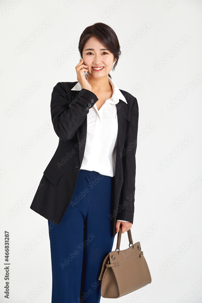 A business woman in her 30s who works on the phone on the move. A business woman in her 30s who works on the phone on the move.