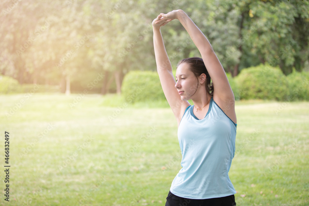 Young beautiful woman stretching body after workout in the park Young beautiful woman stretching body after workout in the park