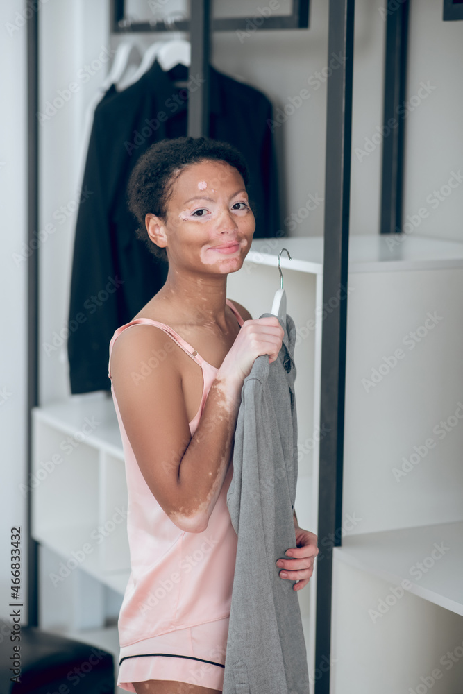 A pretty young female choosing clothes from her wardrobe A pretty young female choosing clothes from her wardrobe