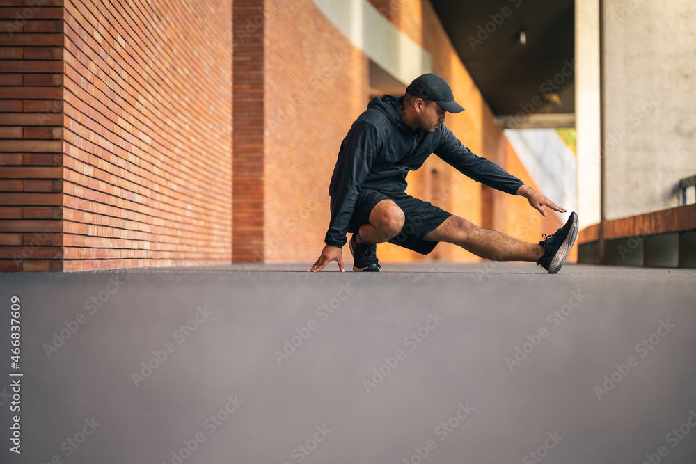Young asian man wearing sportswear running outdoor. Portraits of Indian man  stretching leg before running on the road. Training athlete work out at  outdoor concept. Stock Photo | Adobe Stock