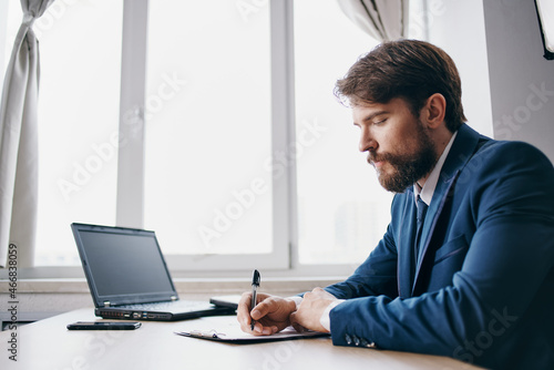 businessmen sitting at a desk in front of a laptop finance