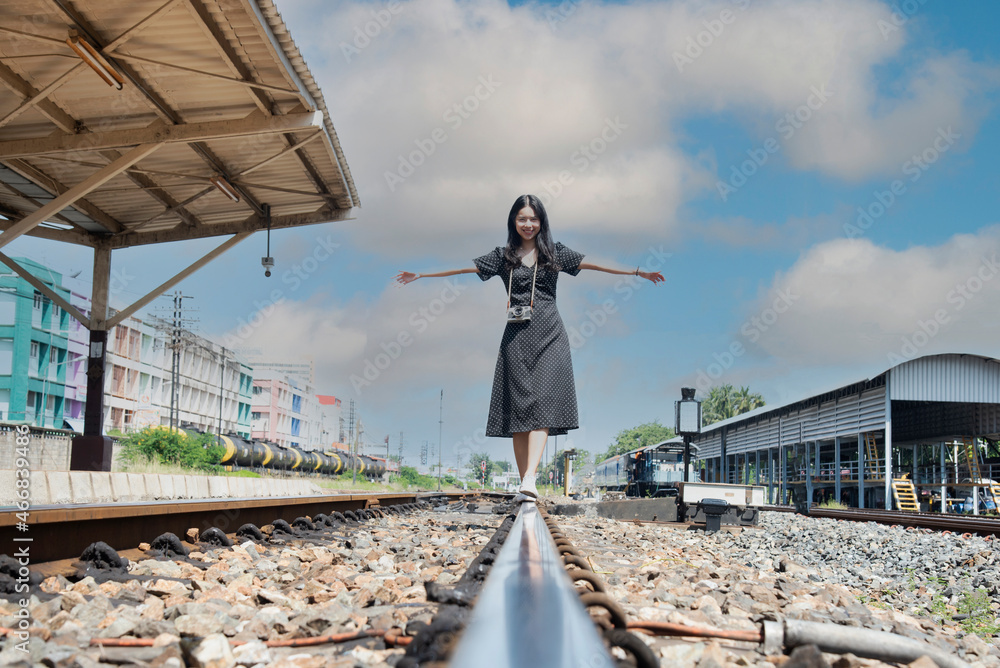 Traveler women walking alone Carrying luggage and waits train on railway station