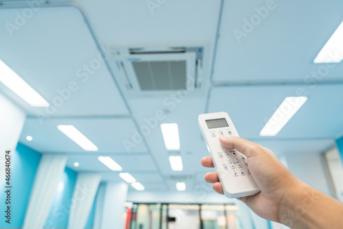 hand holding built-in large air conditioner remote control in the hospital