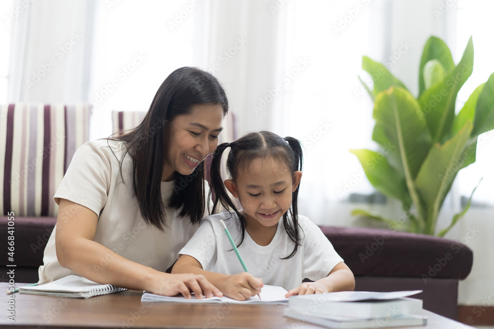 Happy asian little girl with mother teaching homework, Study From Home idea concept Happy asian little girl with mother teaching homework, Study From Home idea concept