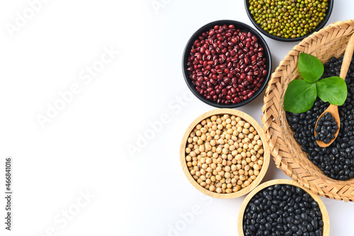 Various beans (black soybean, soybean, azuki bean and mung bean seeds) in a bowl on white background