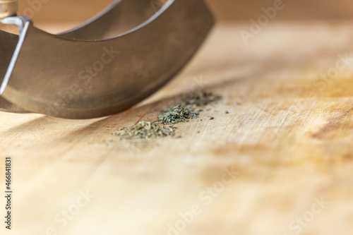 Close-up of different spice in front of a chopping-knife on a wooden cutting board
