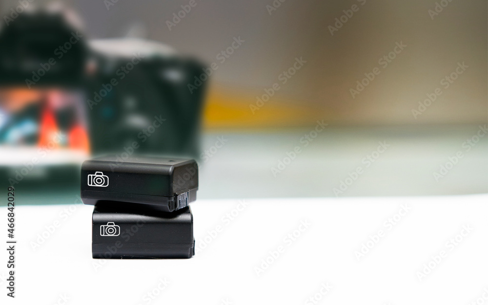 Rechargable camera battery on blur camera background Rechargable camera battery on blur camera background