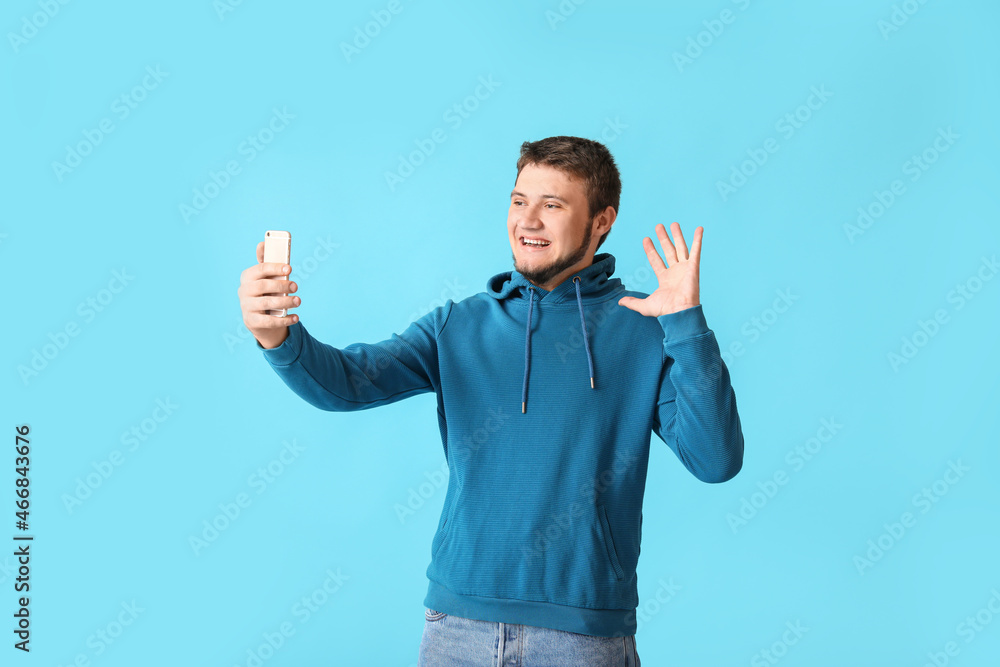 Stylish young man taking selfie on color background Stylish young man taking selfie on color background