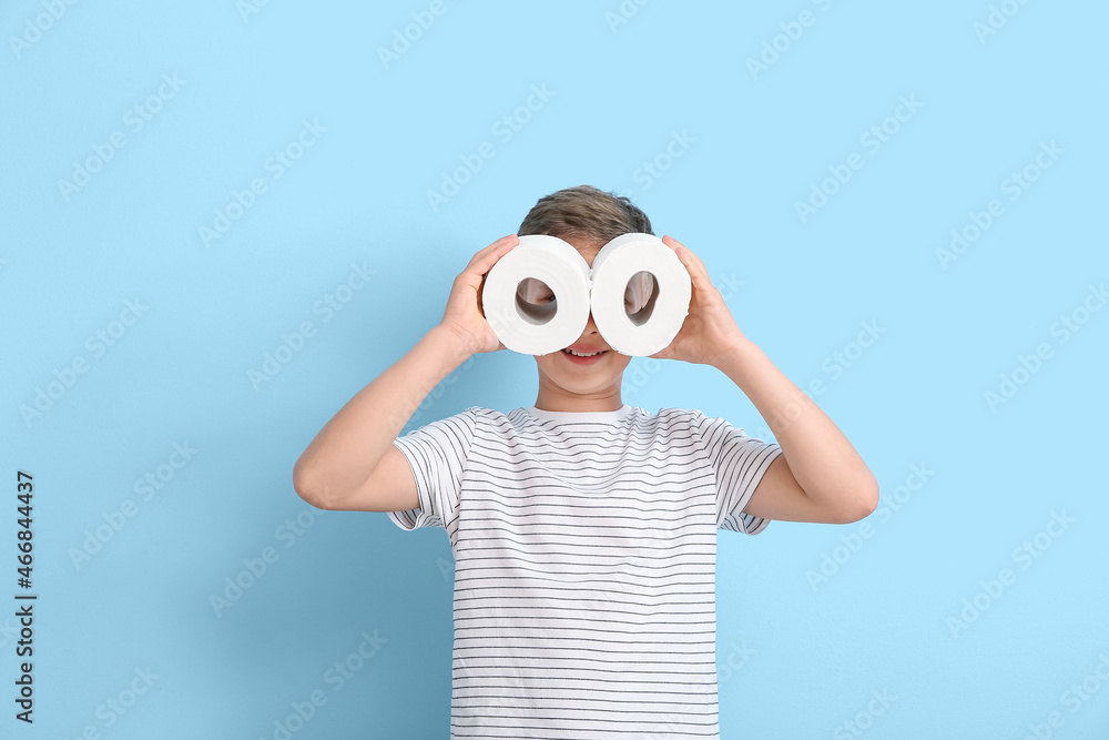 Cute little boy with rolls of toilet paper on blue background Cute little boy with rolls of toilet paper on blue background