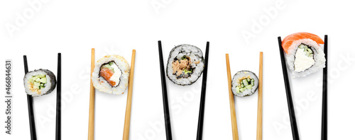 Obraz  z motywem Chopsticks with tasty sushi rolls on white background