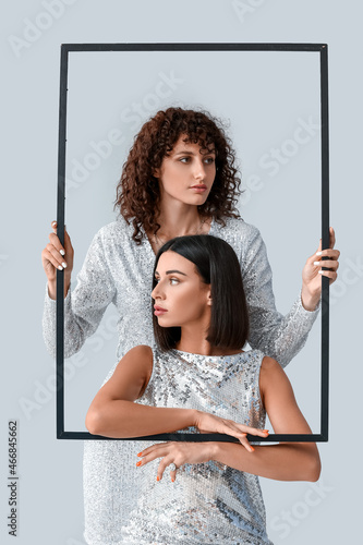 Young sisters with frame on...