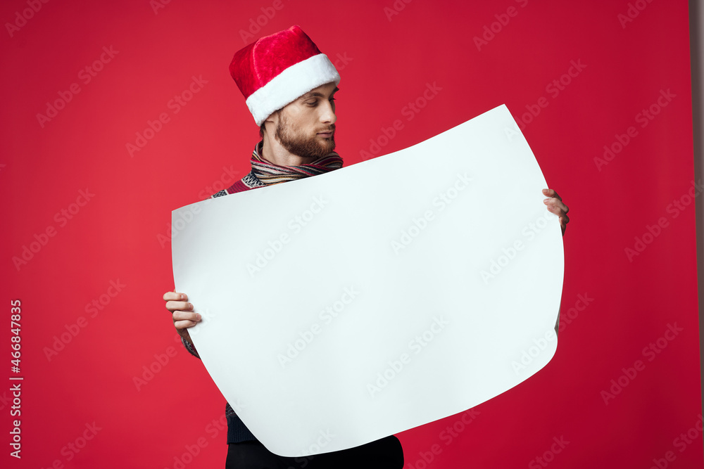 Cheerful man in a santa hat holding a banner holiday isolated background Cheerful man in a santa hat holding a banner holiday isolated background