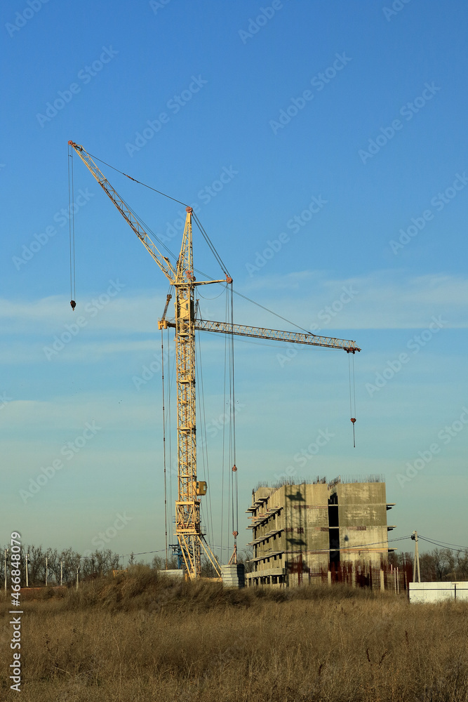 Tower cranes are working on the construction of a new house. Lifting crane. Tower cranes are working on the construction of a new house. Lifting crane.